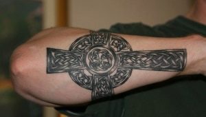 Ανδρικό τατουάζ με τη μορφή σταυρού στο χέρι